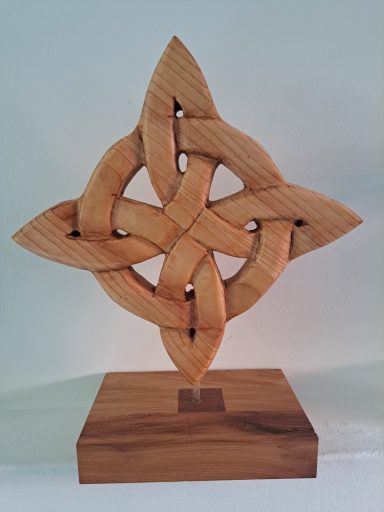 Eeuwige liefde 120 Euro Houten sculptuur in de vorm van een ingewikkeld knoopmotief op een sokkel.