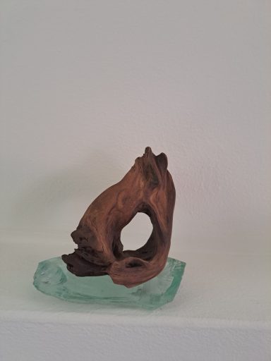 Hout op glas 35 Euro Houten sculptuur van een gestileerde hond op een glazen basis.