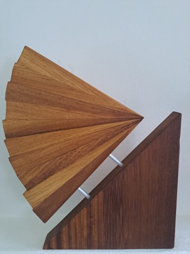 Zonnestralen 120 Euro VERKOCHT Houten sculptuur met spitse en geschulpte vormen, geplaatst op een driehoekige basis.