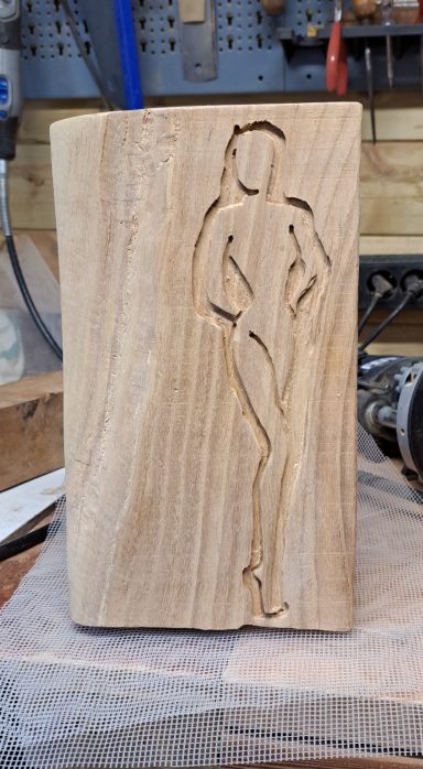 Dame in hout 40 Euro Houten blok met een uitgesneden figuur van een vrouw in een pose.